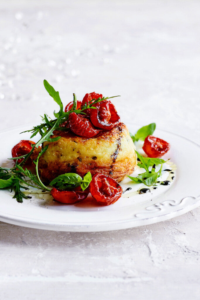 Dubbel gebakken souffle (2st) van parmezaan, geitenkaas en basilicum met topping van rucola en gekaramelliseerde tomaatjes