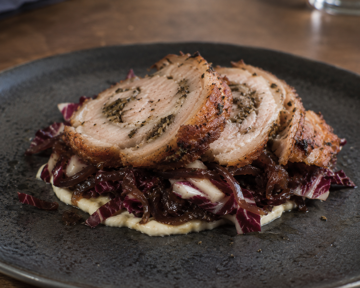 Porchetta (Italiaans gekruid buikspek) met radiccio sla, geconfijte ui en aioli.