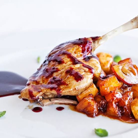 Confit de canard met aardappeltjes, wortel en een saus van rood fruit.