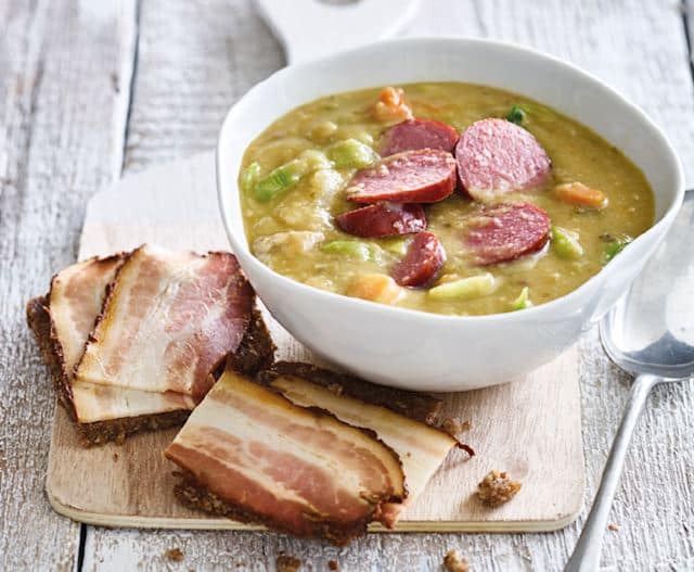 Huisgemaakte erwtensoep met rookworst en roggebrood met katenspek