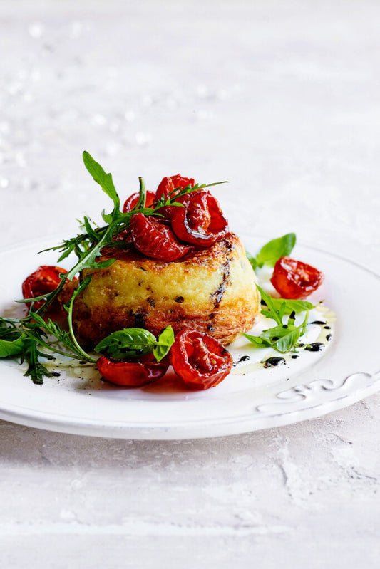 Dubbel gebakken souffle (2st) van parmezaan, geitenkaas en basilicum met topping van rucola en gekaramelliseerde tomaatjes